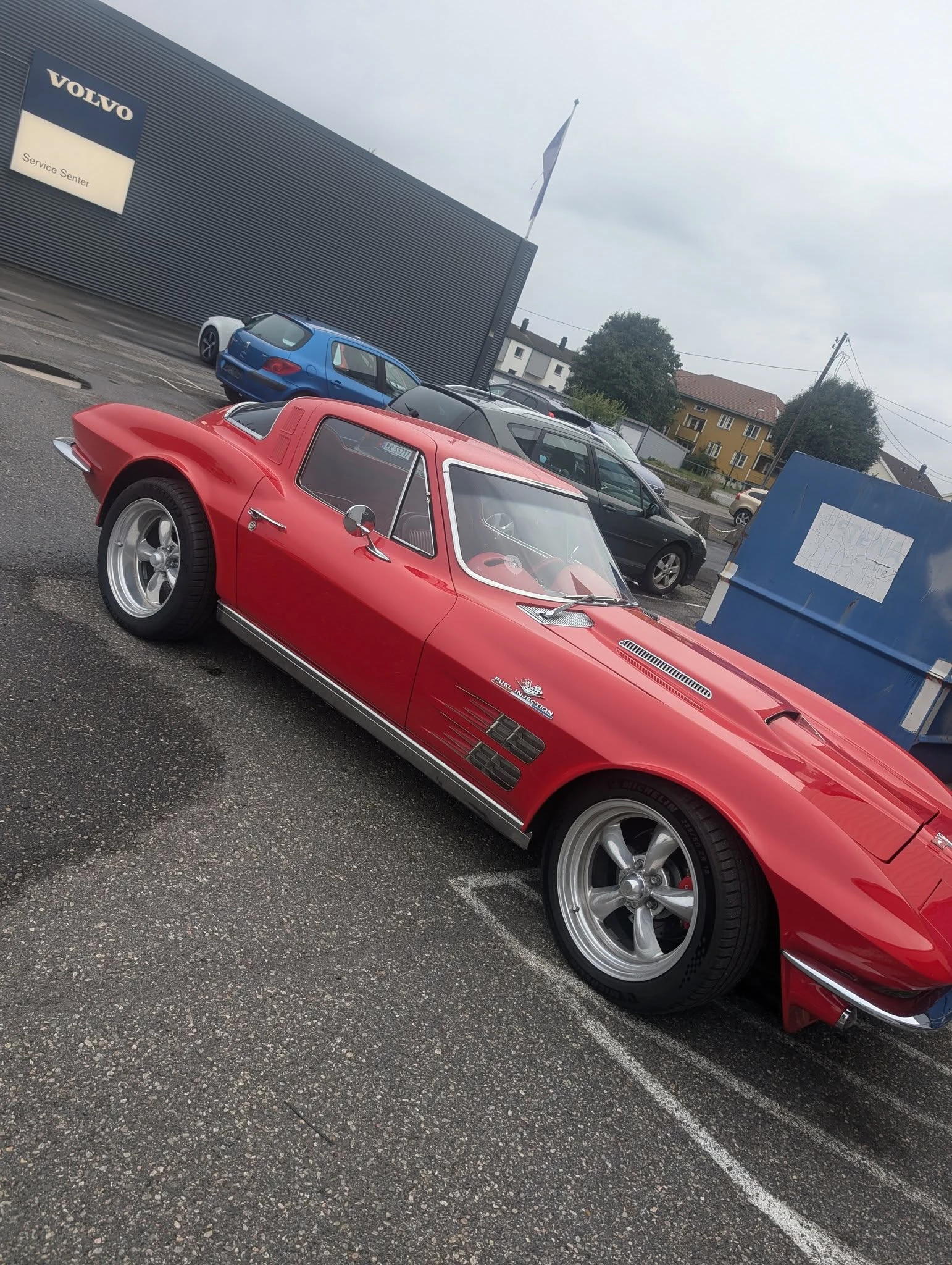 Klassisk rød Corvette C2 utenfor verkstedet